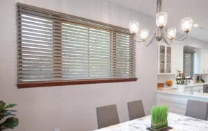 a dining table and chairs in a room with blinds